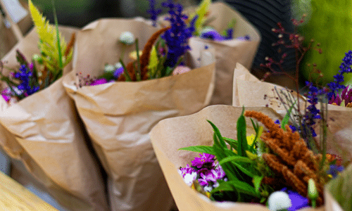 A bunch of bags filled with flowers are sitting on a table.