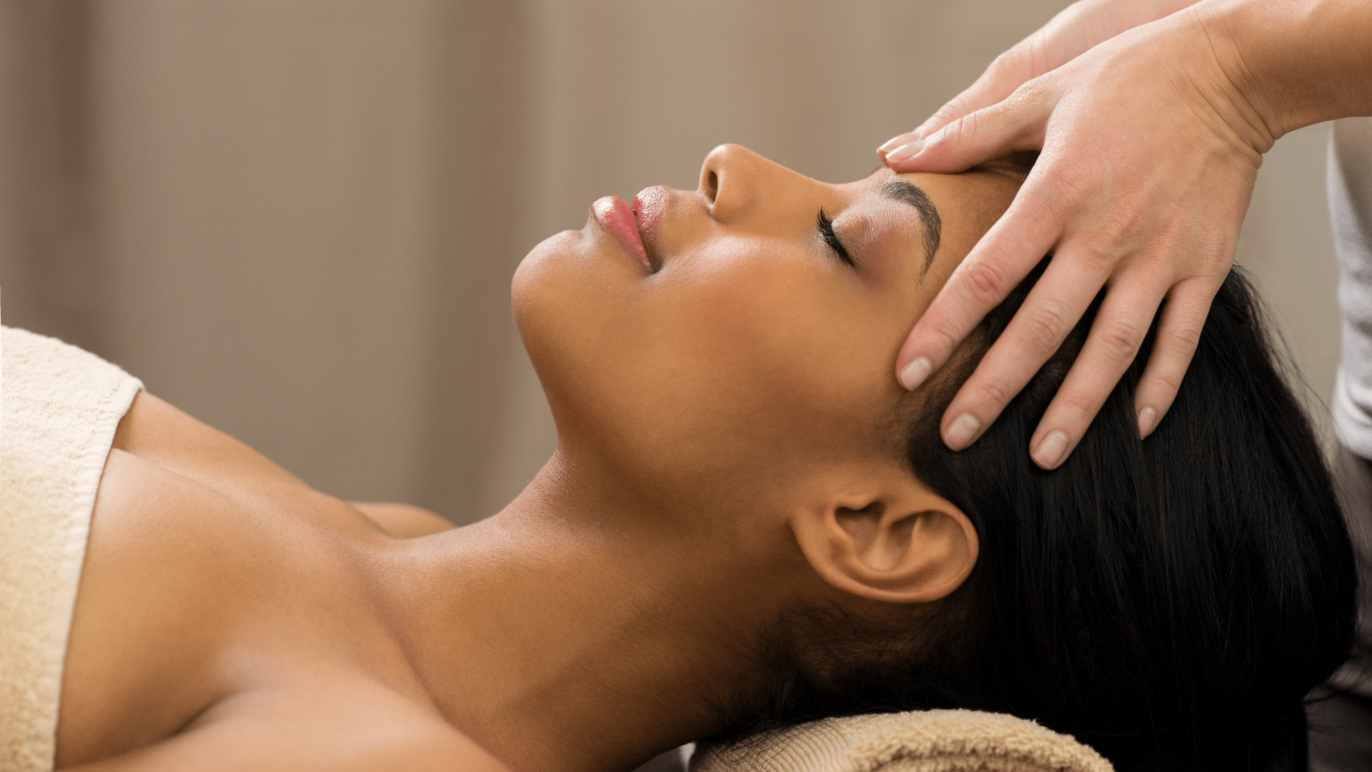 A woman is getting a head massage at a spa.