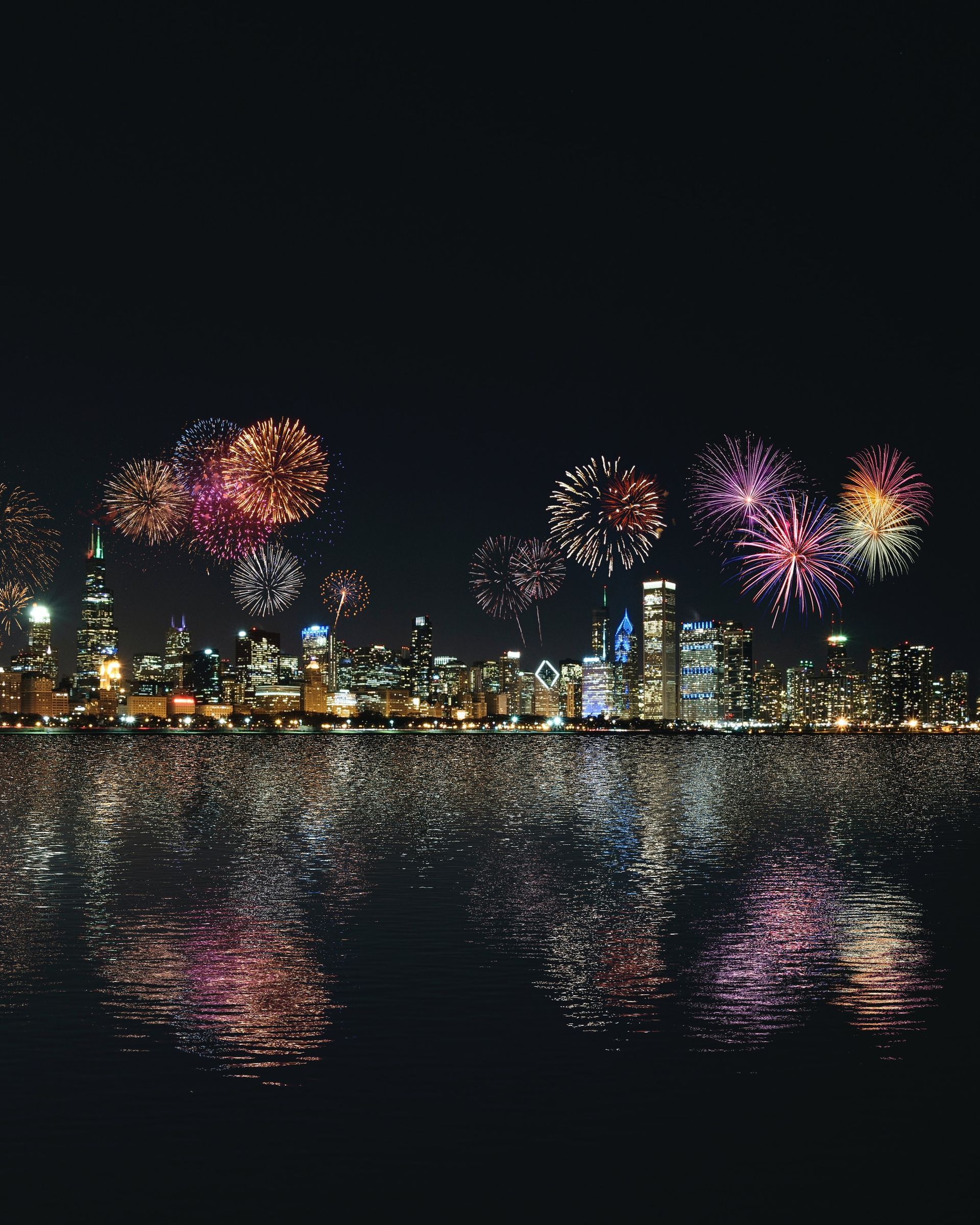 Fireworks are displayed over a city at night