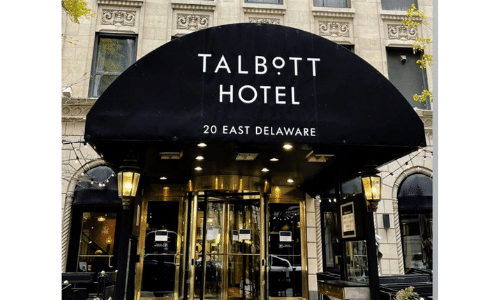 The talbott hotel is located in delaware and has a black awning over the entrance.