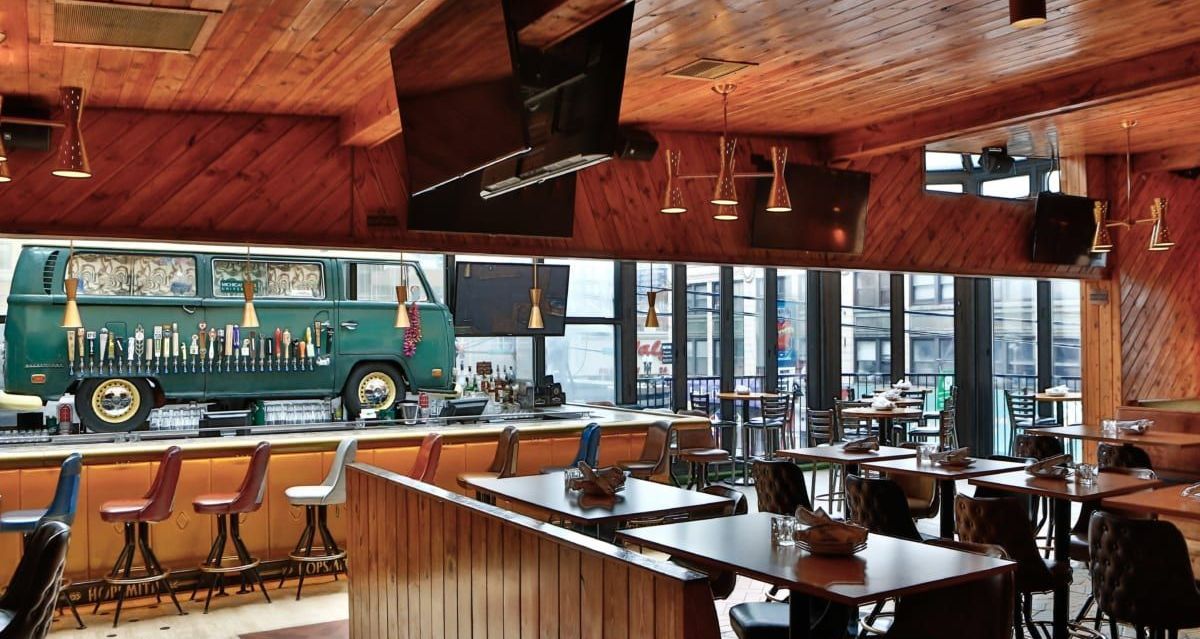 A restaurant with tables and chairs and a bus on the wall
