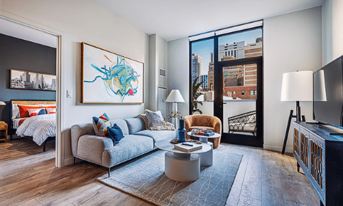 A living room with a couch , chair , coffee table and television.