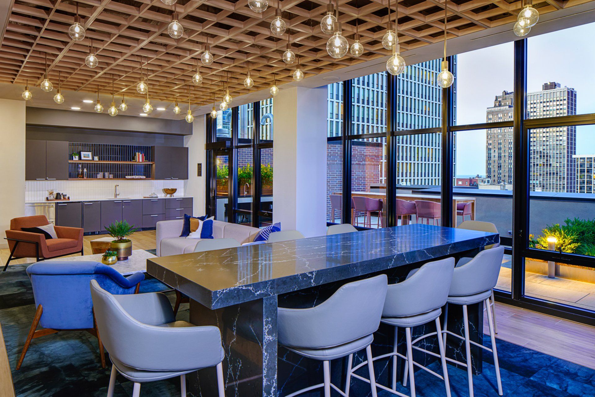 Apartment clubhouse with an oversized island and bar seating at Gild Apartment.
