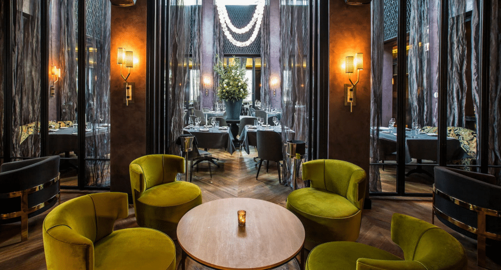 A dining room with green chairs and a round table.