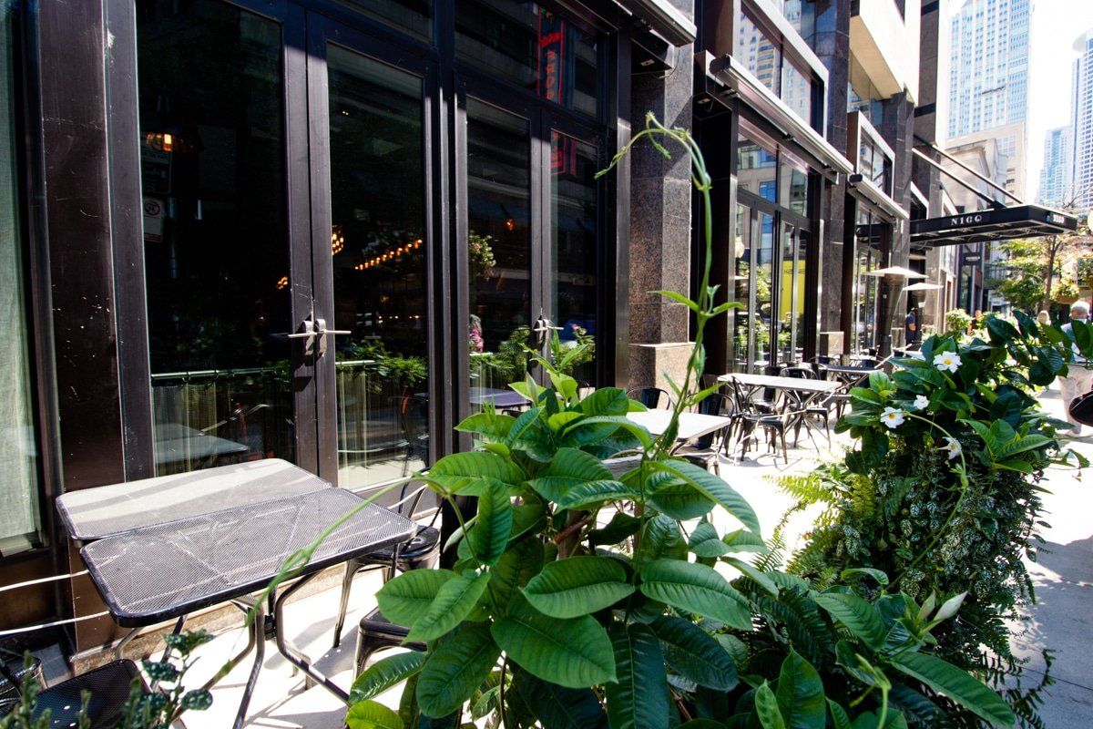A restaurant with tables and chairs outside of it
