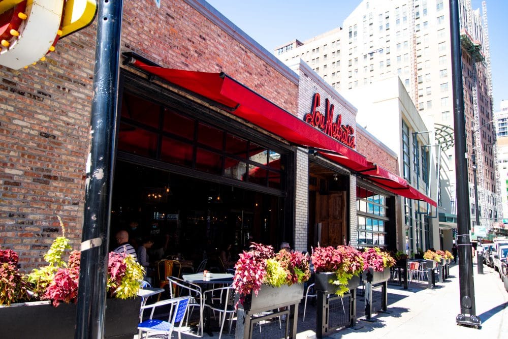 A restaurant with tables and chairs outside of it.
