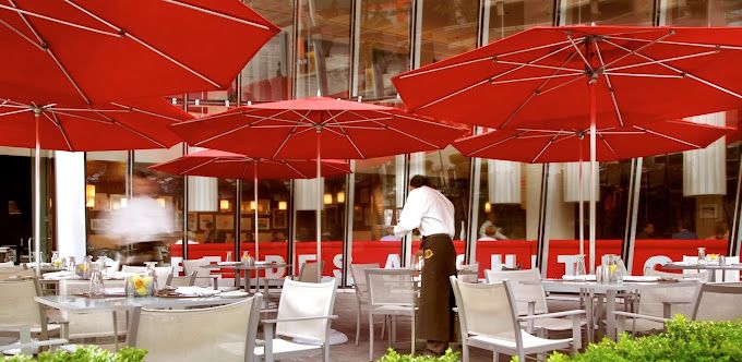 A restaurant with tables and chairs and red umbrellas