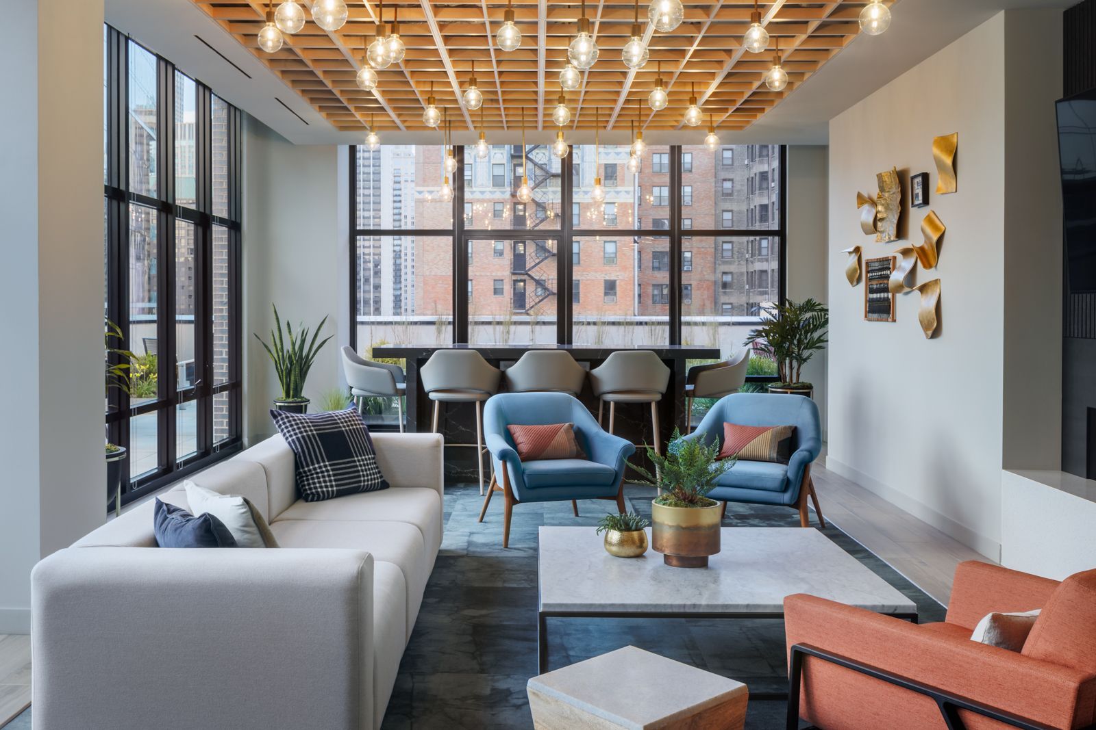Modern clubhouse with sofa, chairs, and coffee table at Gild Apartment.
