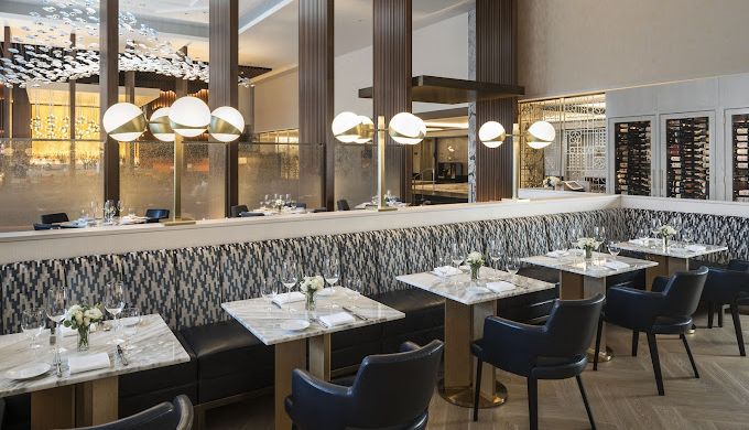 A restaurant with tables and chairs and a large window.