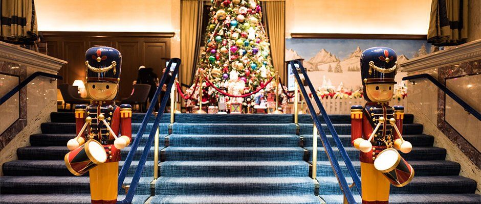A staircase with a christmas tree and two nutcrackers on the steps.