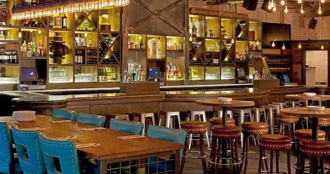 A restaurant with tables and chairs and a bar.