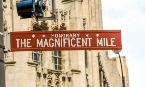 A red street sign that says honorary the magnificent mile.