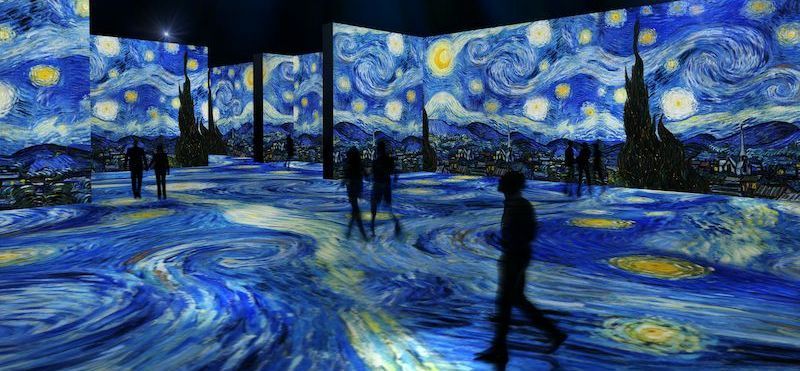 A group of people are walking in front of a starry night painting.