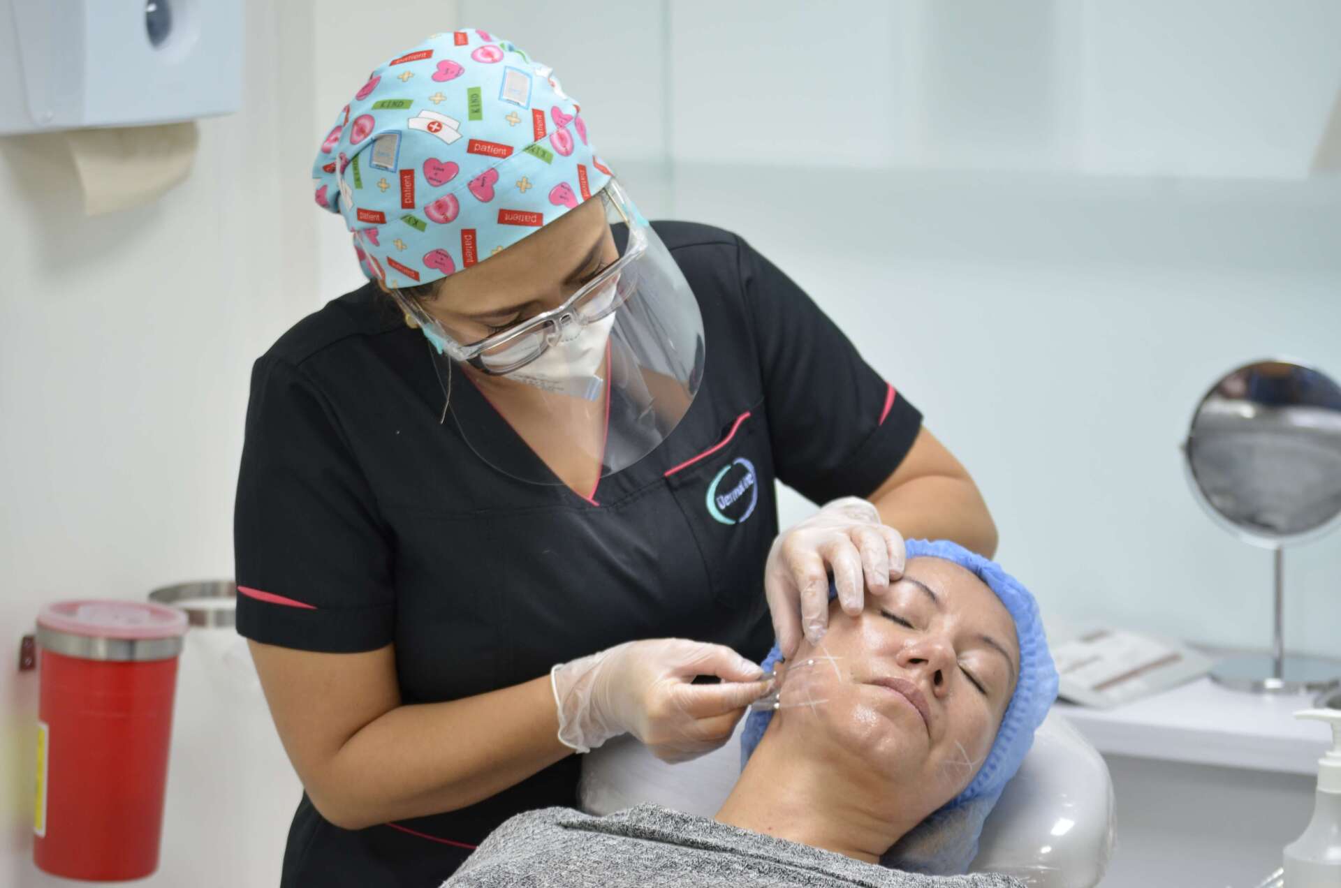 Especialista realizando procedimiento estético facial a una paciente