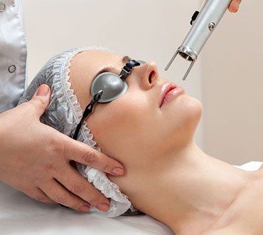Mujer recibiendo tratamiento láser facial
