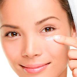 Mujer aplicando crema en el contorno de ojos