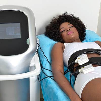 Mujer recibiendo tratamiento de lipo láser en camilla
