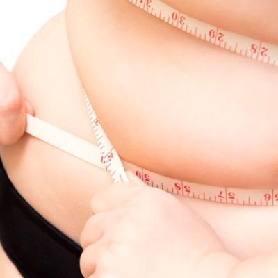 Medición corporal con cinta métrica en zona abdominal