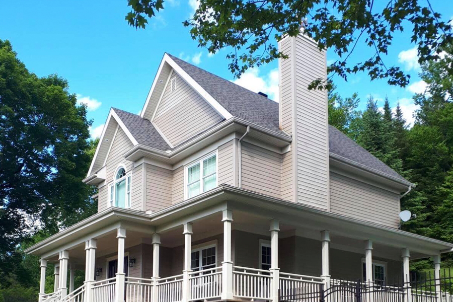 Une grande maison avec un porche et une cheminée