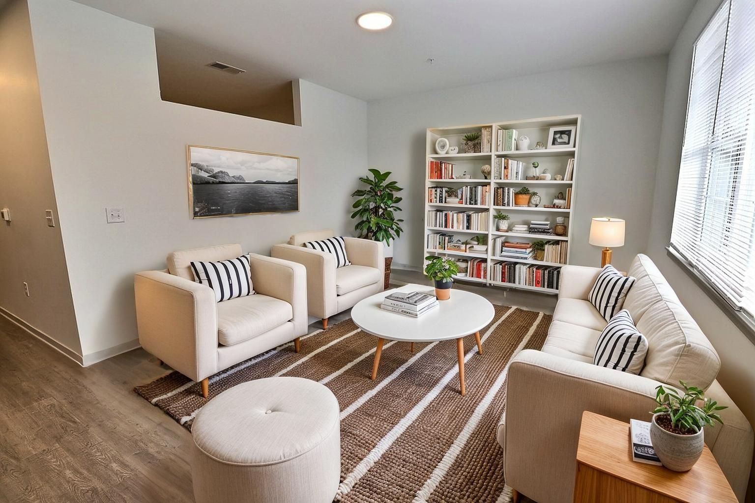 Living room with a couch, two chairs and bookshelf