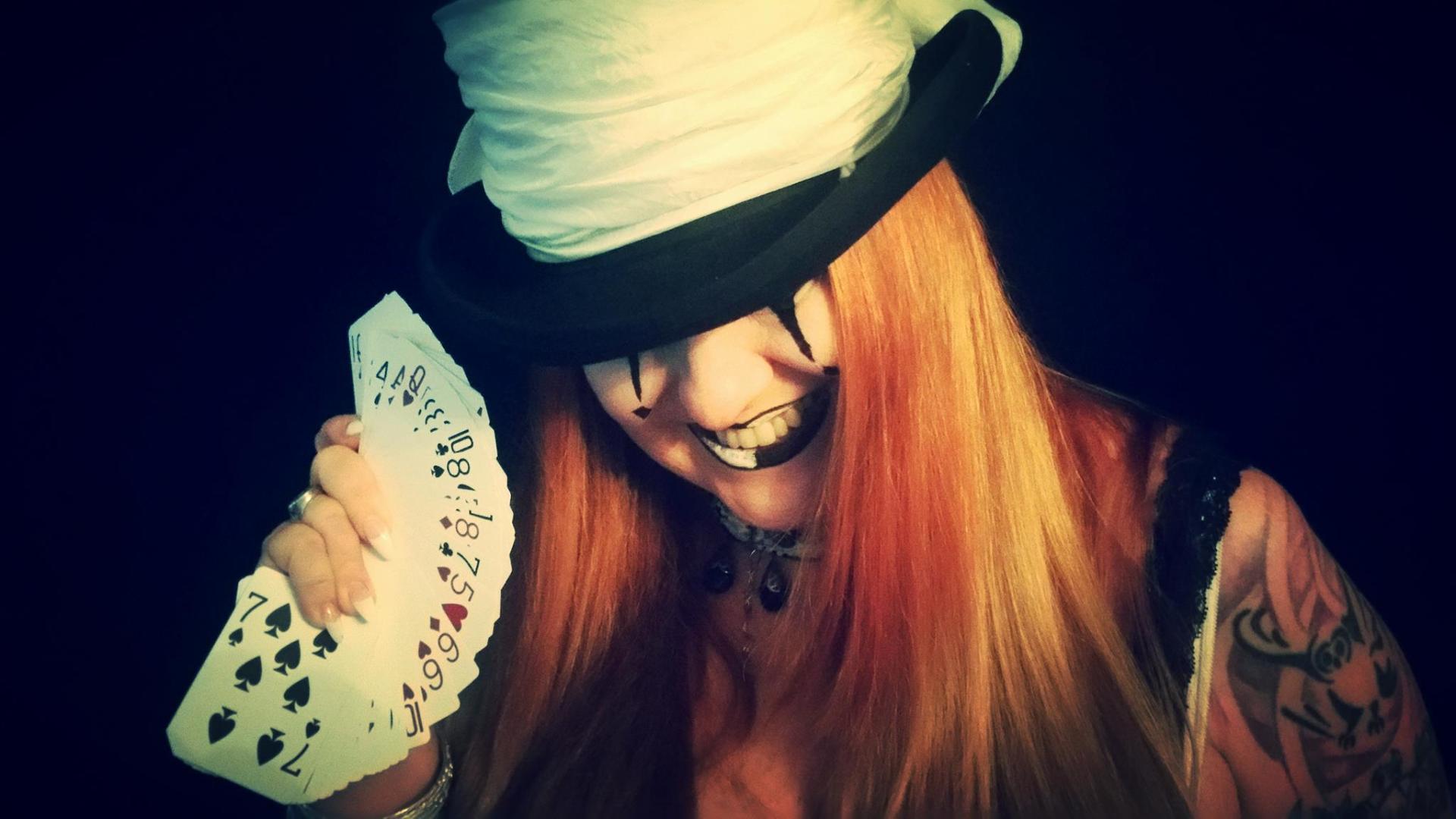 A woman in a top hat is holding a deck of playing cards, representing Fortuna.