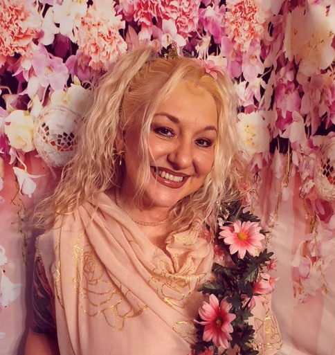 A woman in a pink dress with flowers in her hair, representing Persephone.