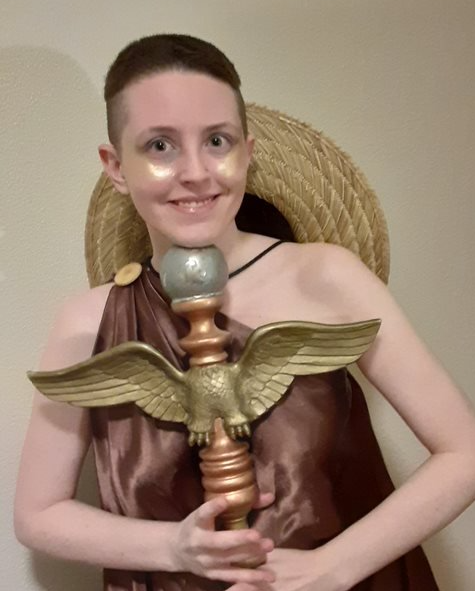 A woman is holding a staff of a bird on a pole