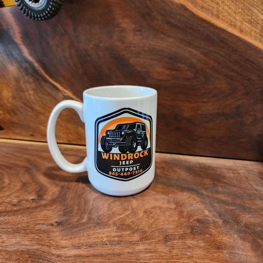 White mug with Windrock Off Road Outpost logo on a wood-grain background