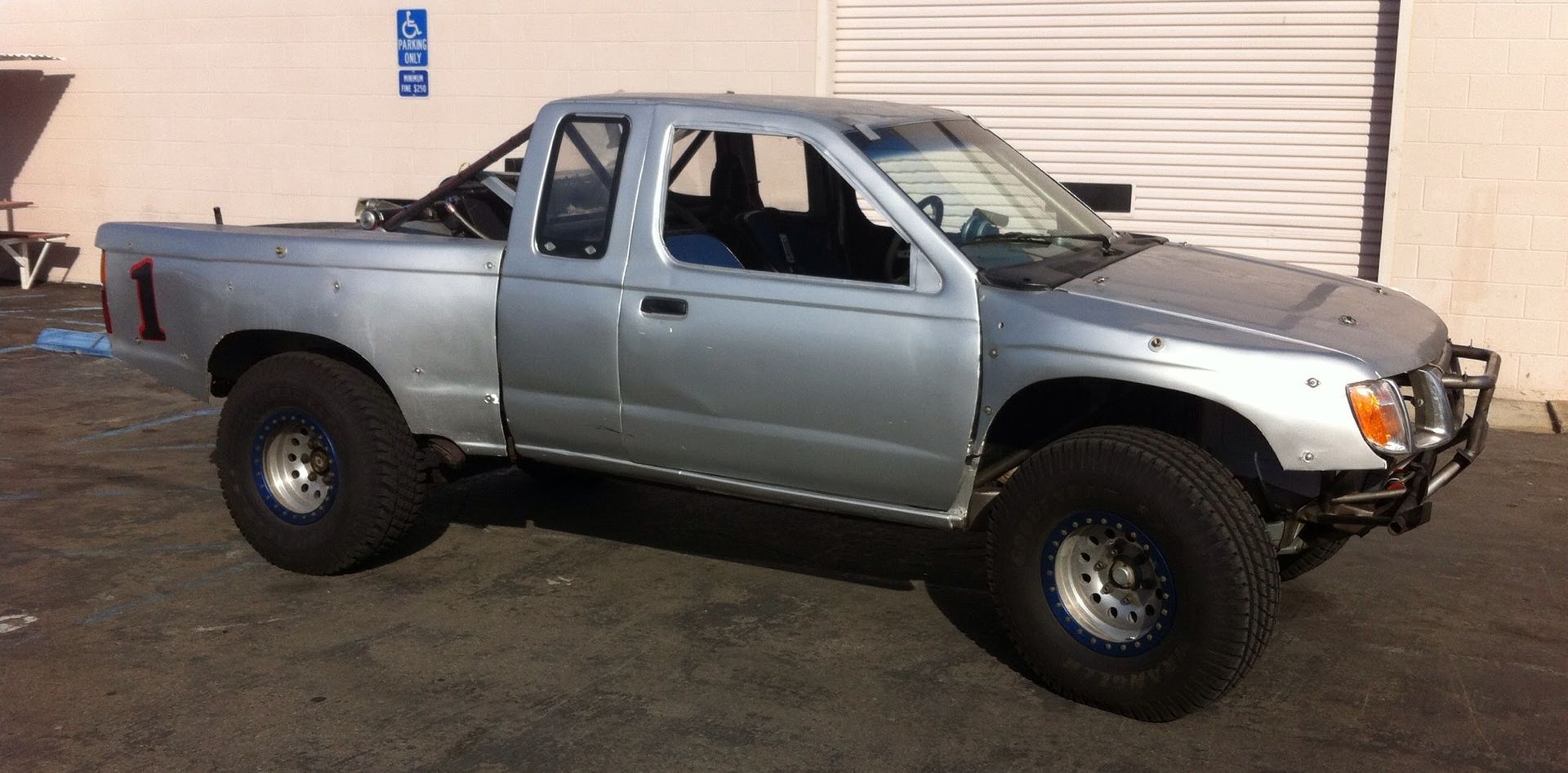 Silver pickup truck parked in front of a garage door