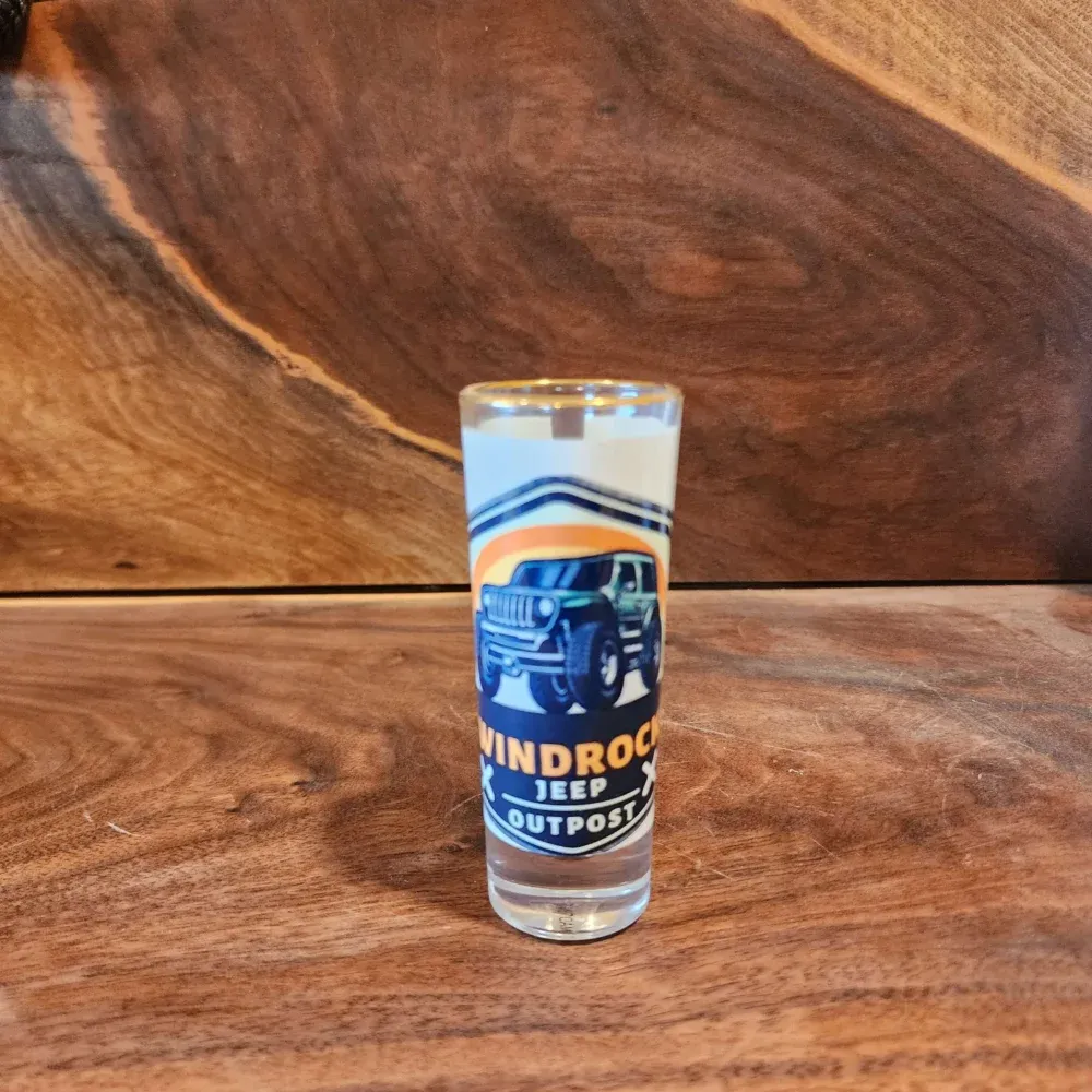 Clear glass Windrock beer glass on a wooden surface with a blue truck design and amber liquid inside