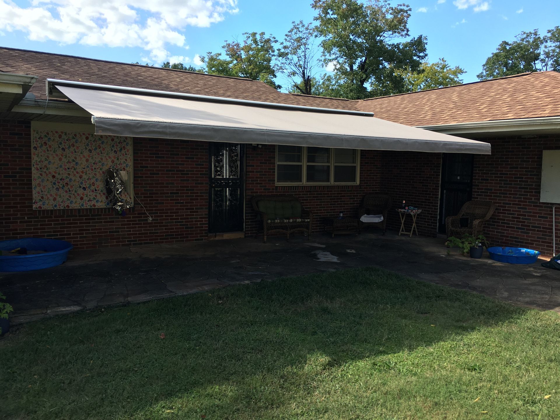 Brick building exterior with a retractable awning over the doors.