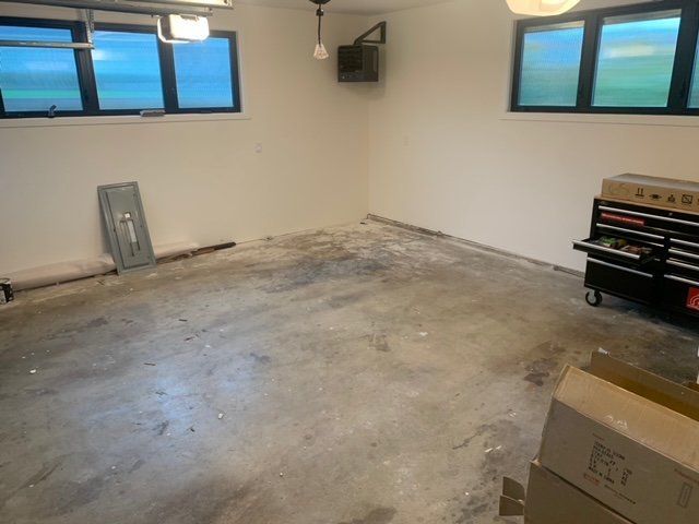 A room with a lot of windows and boxes on the floor