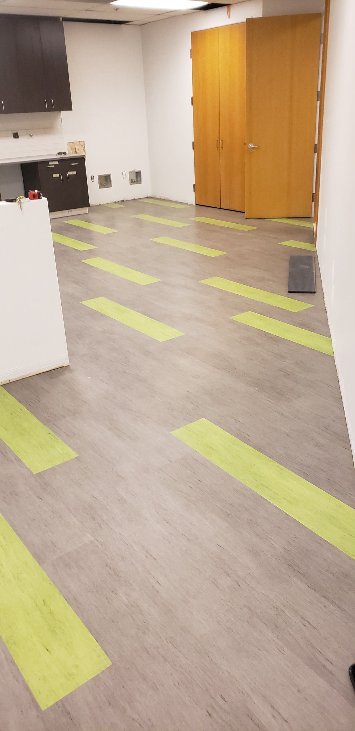 A room with a wooden floor and green stripes on it.