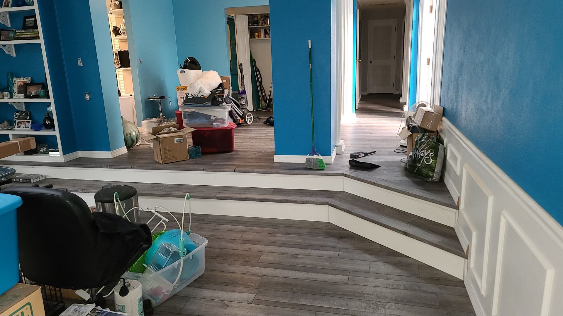A living room with blue walls and a wooden floor.