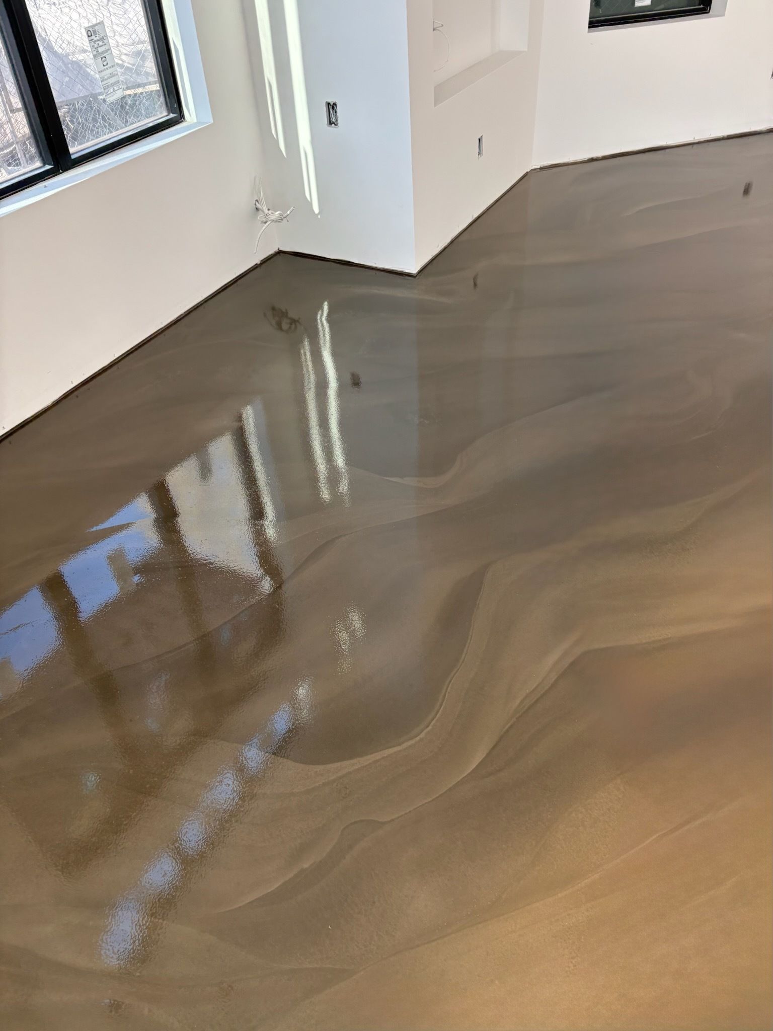Flooded interior room with standing water reflecting windows and walls