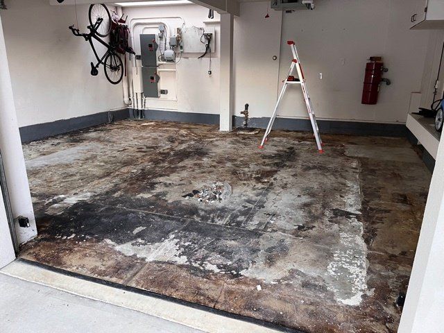 A dirty garage with a ladder and a bicycle on the wall.