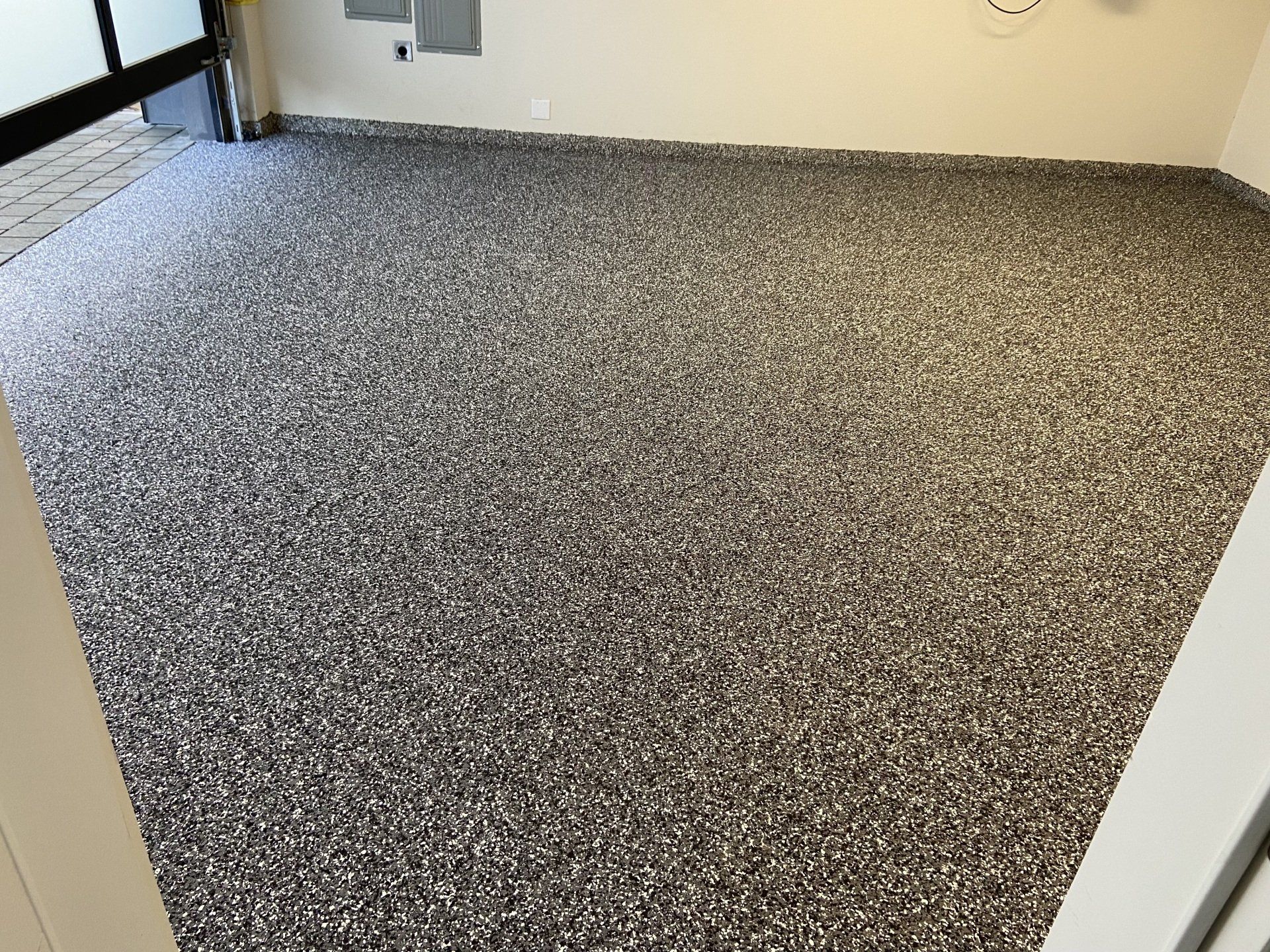 A large carpeted floor in a room with a clock on the wall.