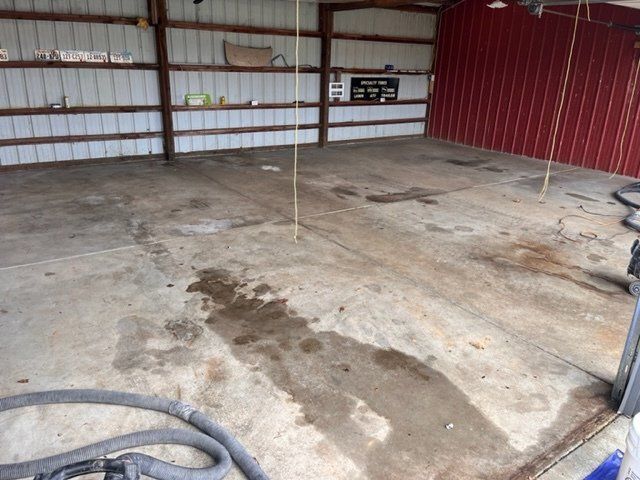 An empty garage with a vacuum hose in the foreground