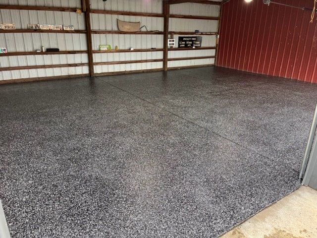 A garage with a gray floor and a red wall