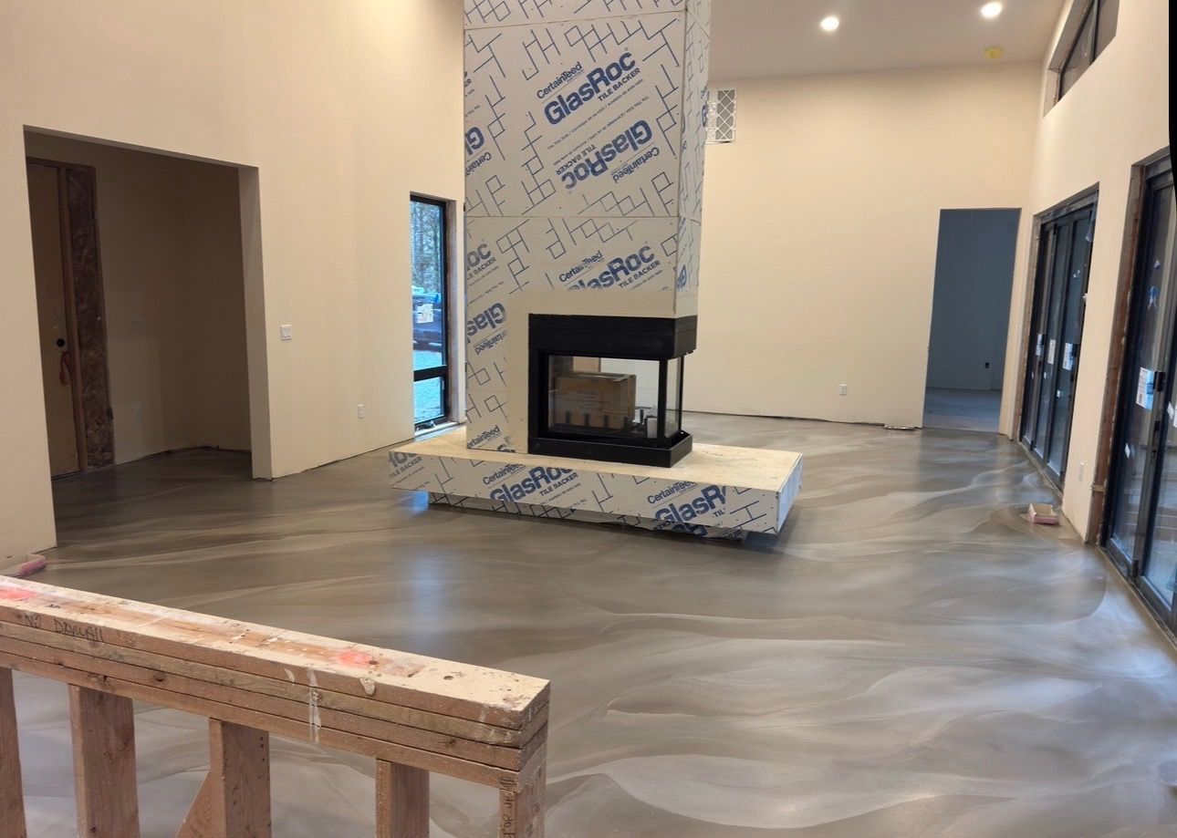 Modern living room under construction with a fireplace, tiled floor, and protective coverings on the walls