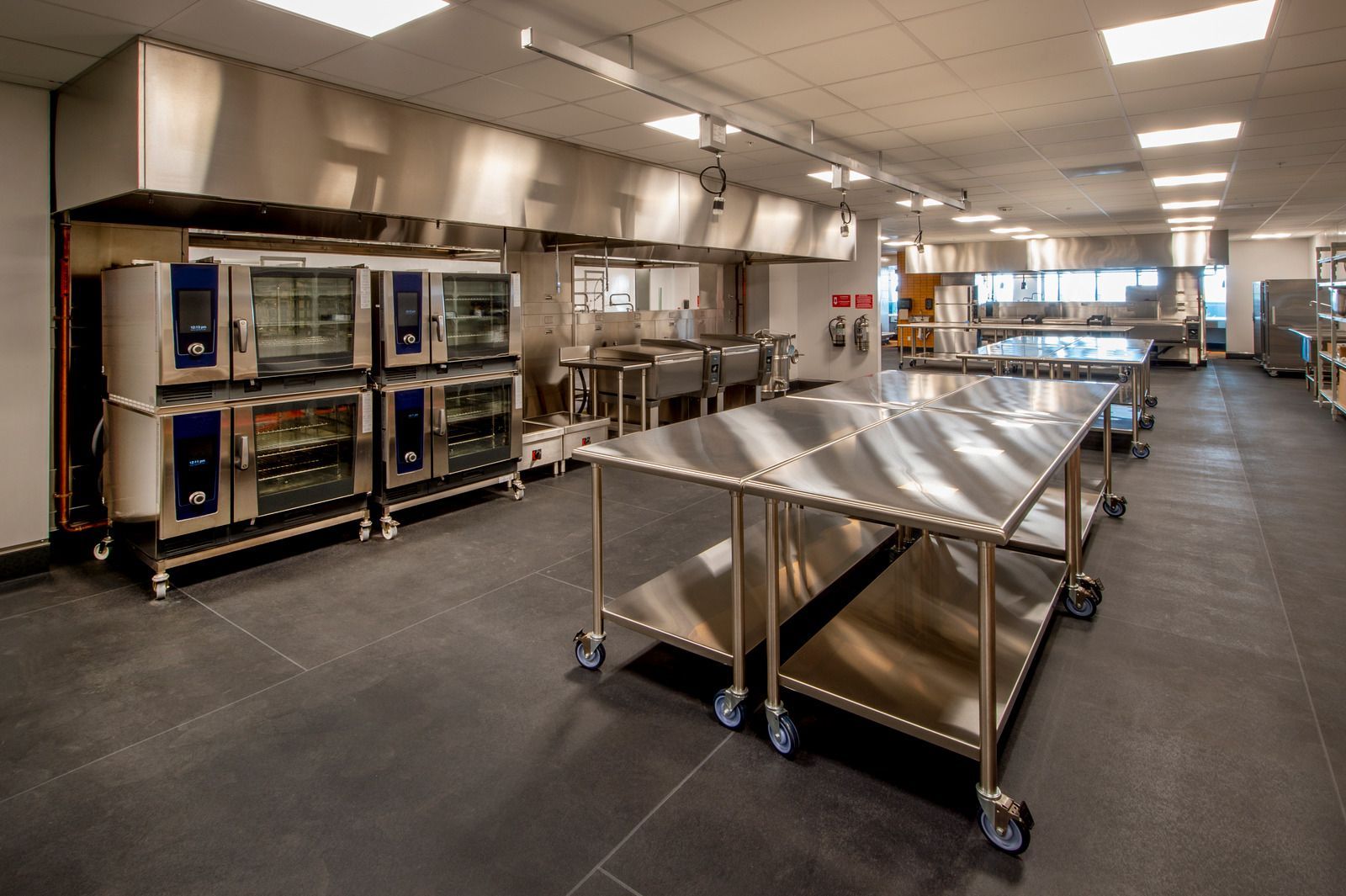 A large kitchen with stainless steel tables and ovens