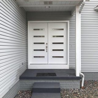 White double front door with horizontal windows and a small dark porch step at the entrance