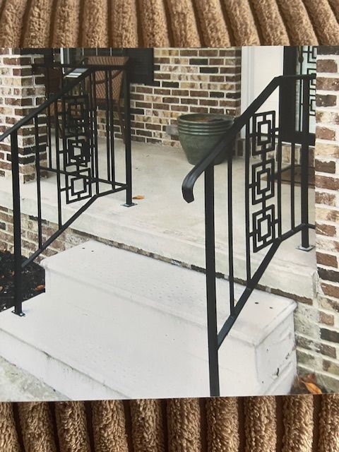 Brick house porch steps with black metal railings and white concrete stoop