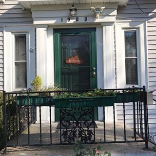 Front entrance to a house with two black metal security doors and a small concrete stoop.