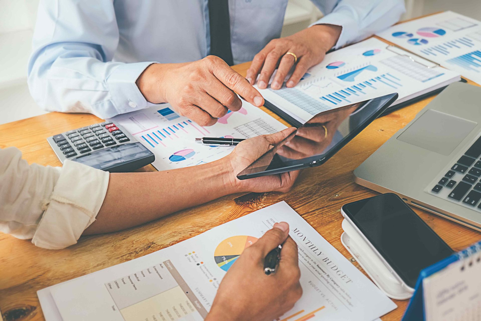 Accounting professionals reviewing financial reports and corporate accounting records during a busin
