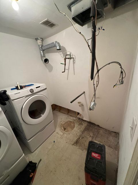 A laundry room with a washer and dryer and a vacuum cleaner.