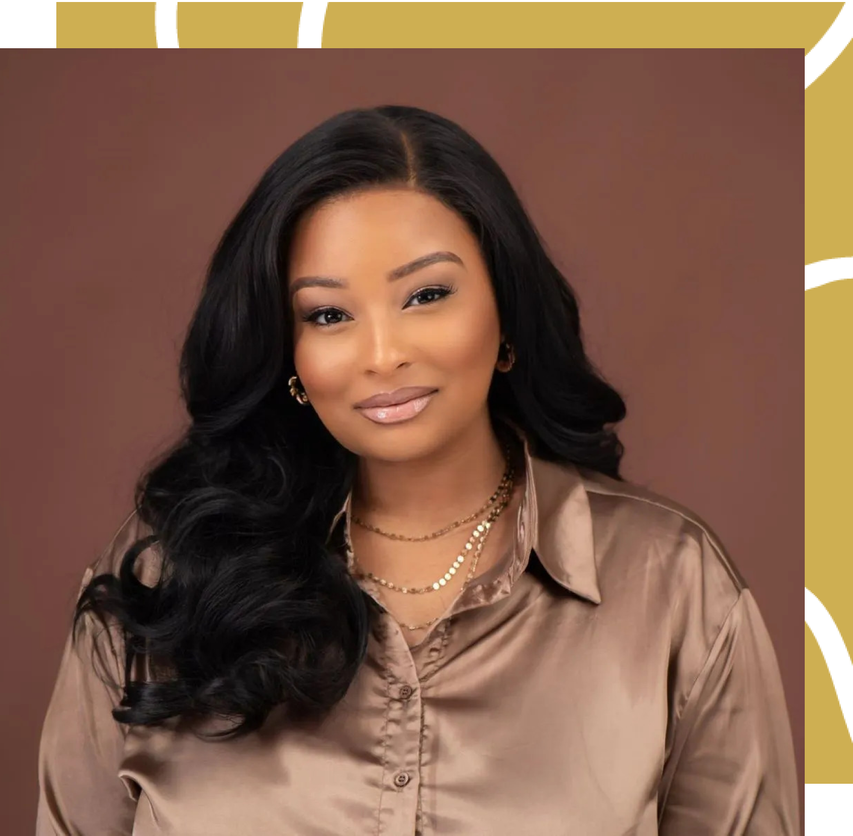 A woman with long black hair is wearing a brown shirt and a gold necklace