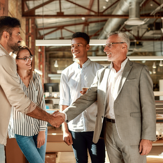 A group of people are shaking hands in an office.