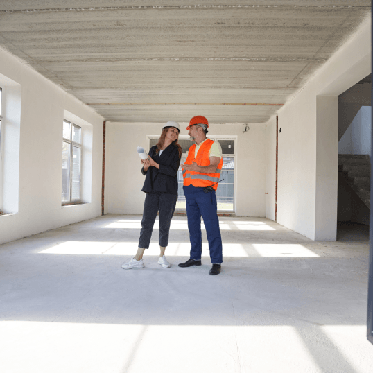 A man and a woman are standing in an empty room