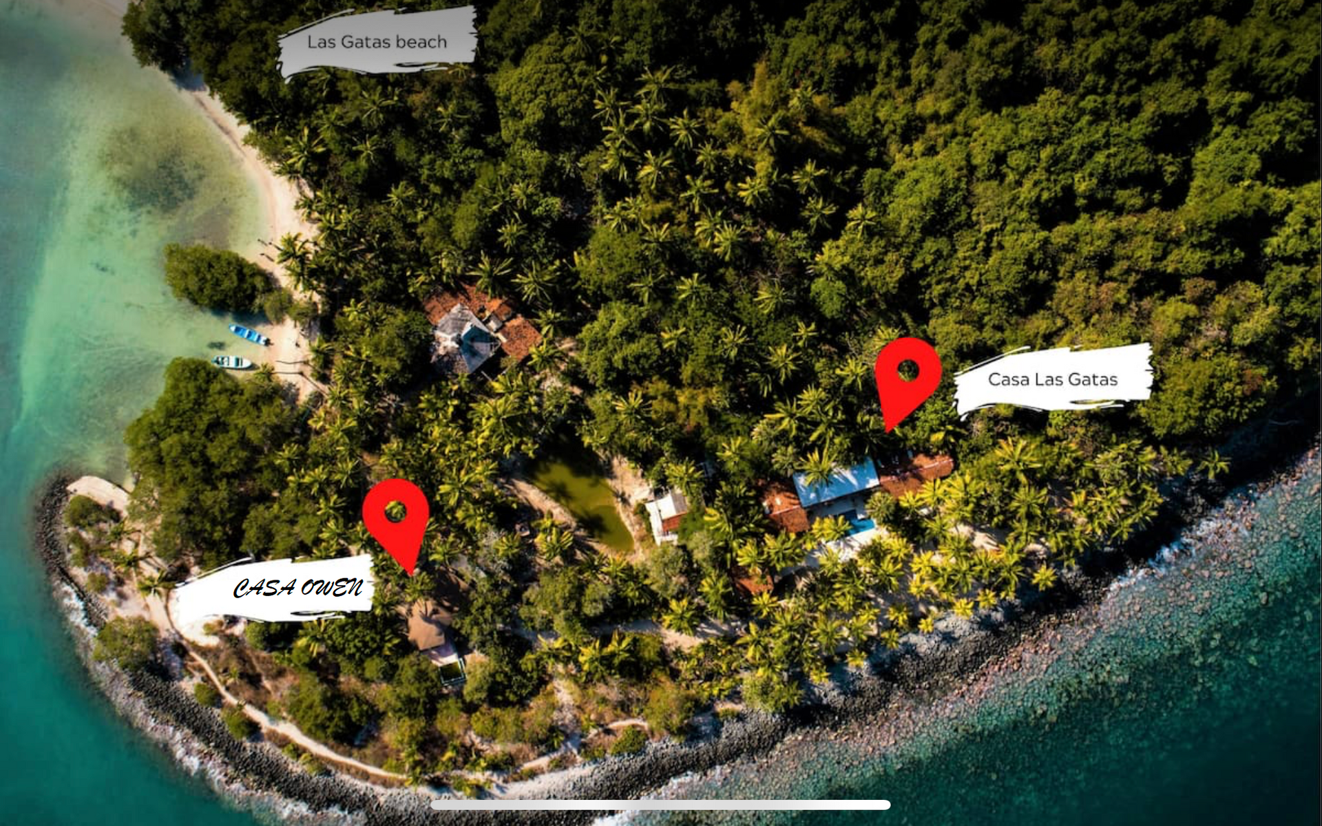 Vista aérea de una isla tropical con marcadores de ubicación rojos: 